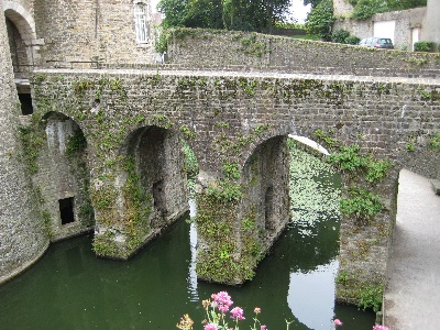 a large stone bridge spanning a body of water next to tall buildings