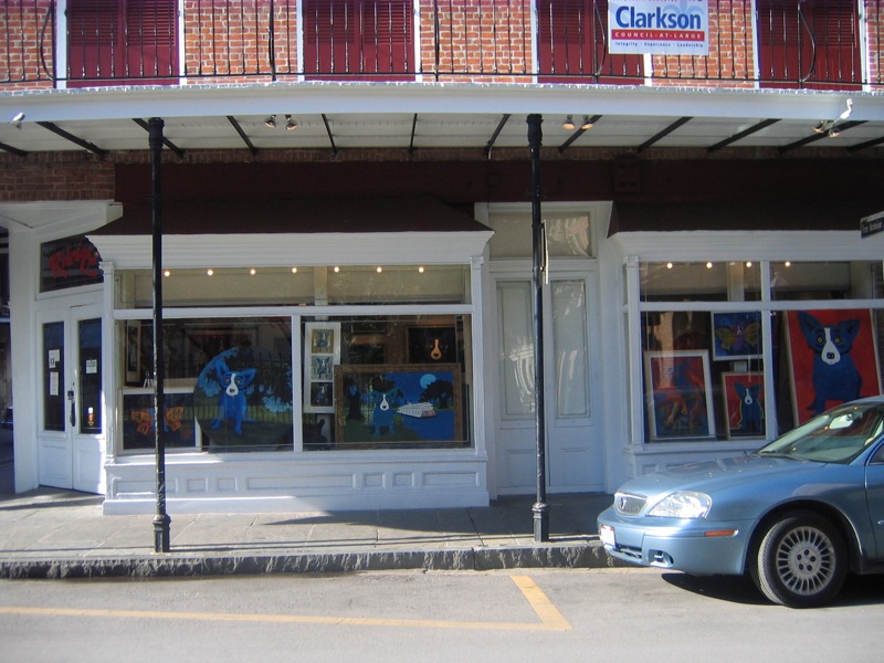 a silver car is parked in front of a storefront