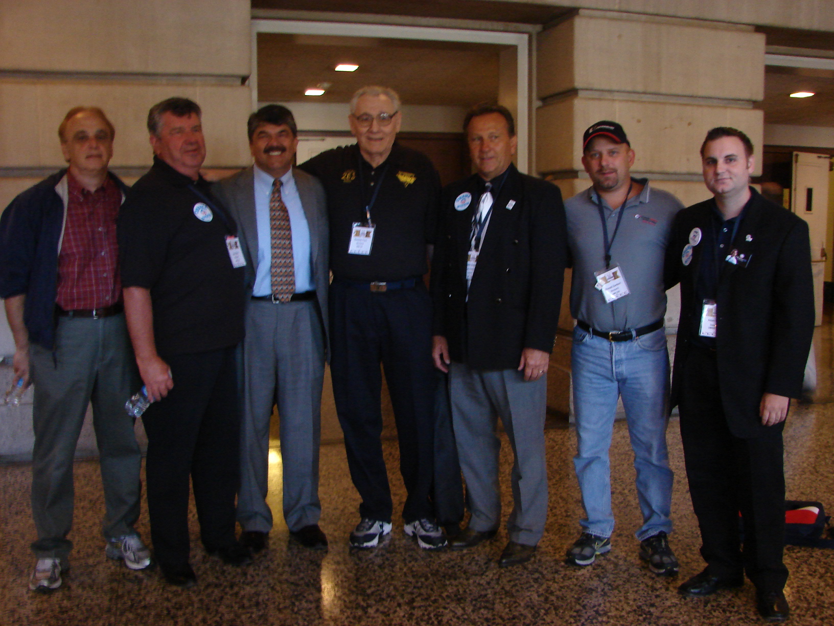 group of men posing in an airport lobby for a po