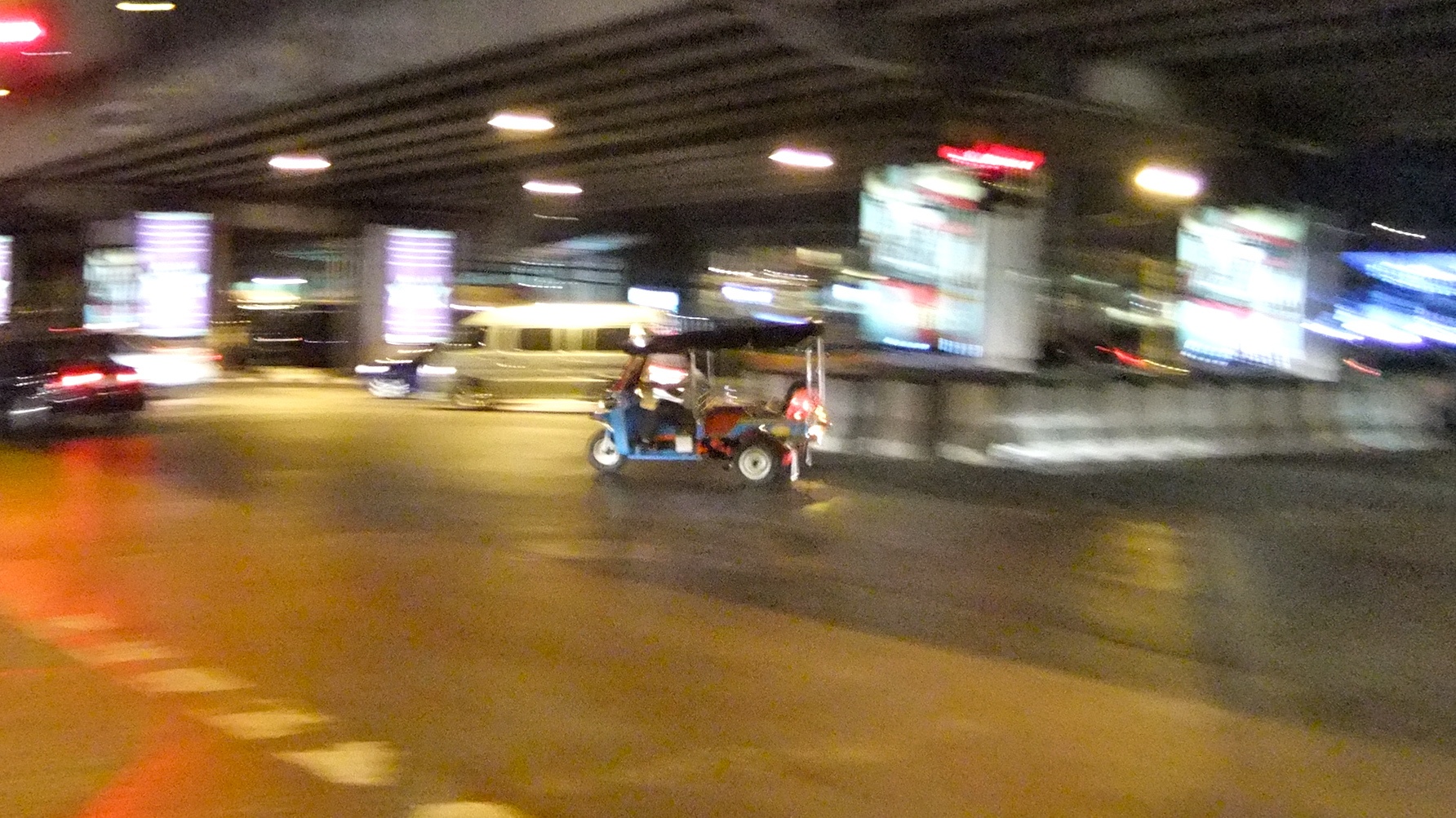 blurry pograph of a vehicle driving under a bridge