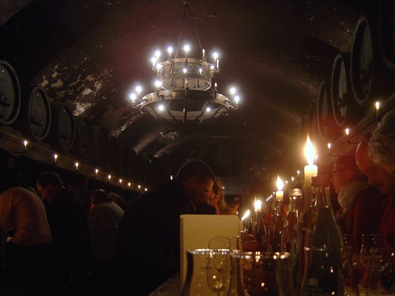 many people and their wine glasses with the lights on in the background