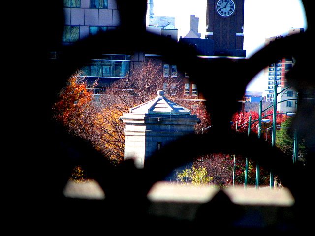 a picture through a wire frame of a large clock tower in the distance