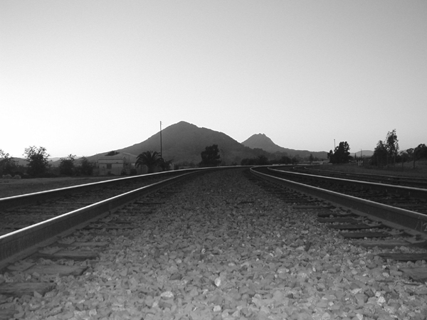 a view of mountains from behind the train tracks