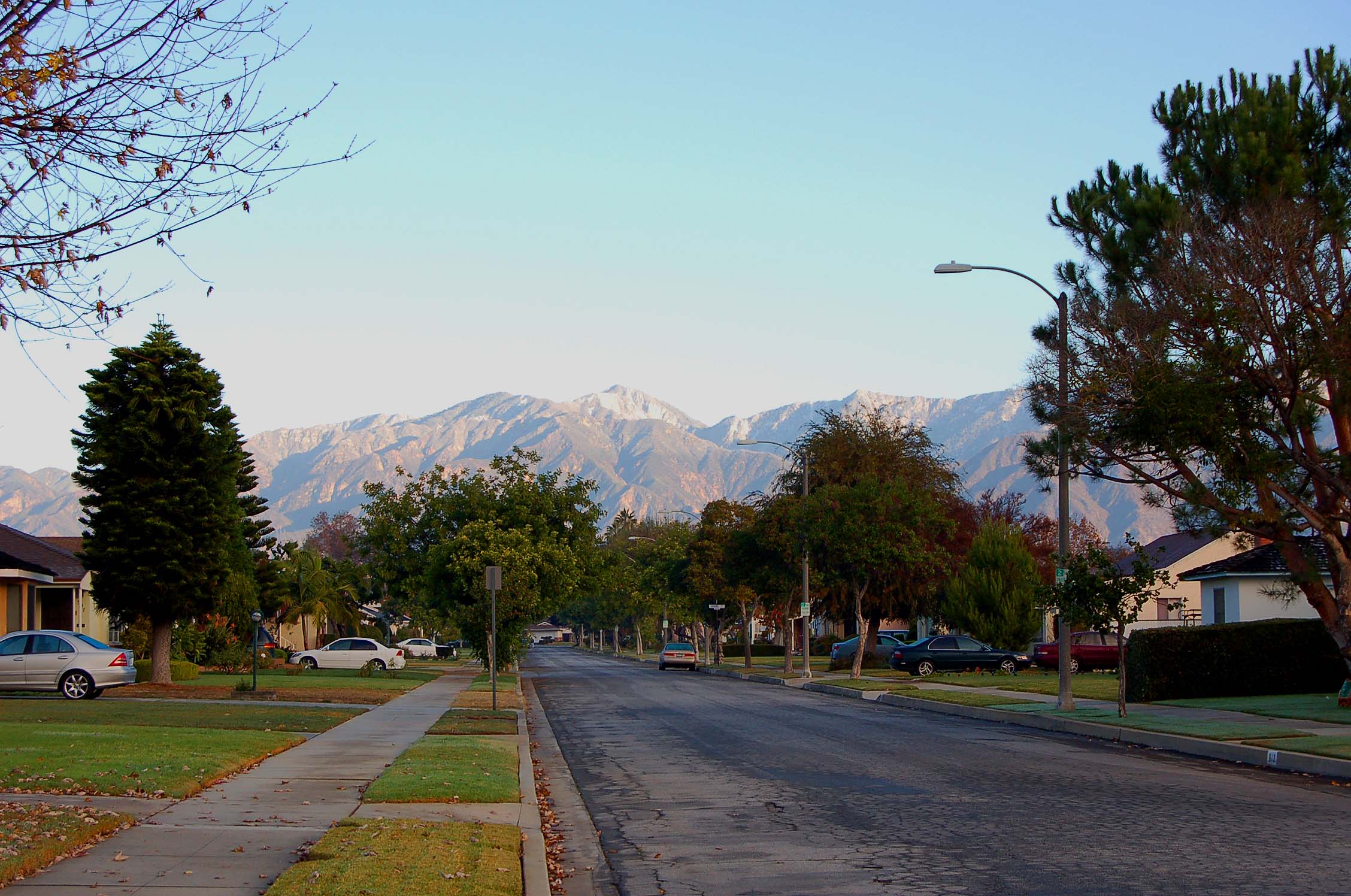 a street with houses on both sides with mountains in the background