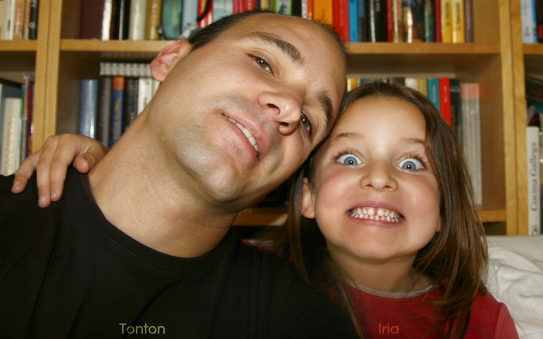 a man and girl are smiling with books in the background