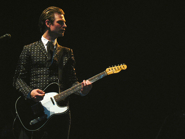 a man in a suit playing an electric guitar