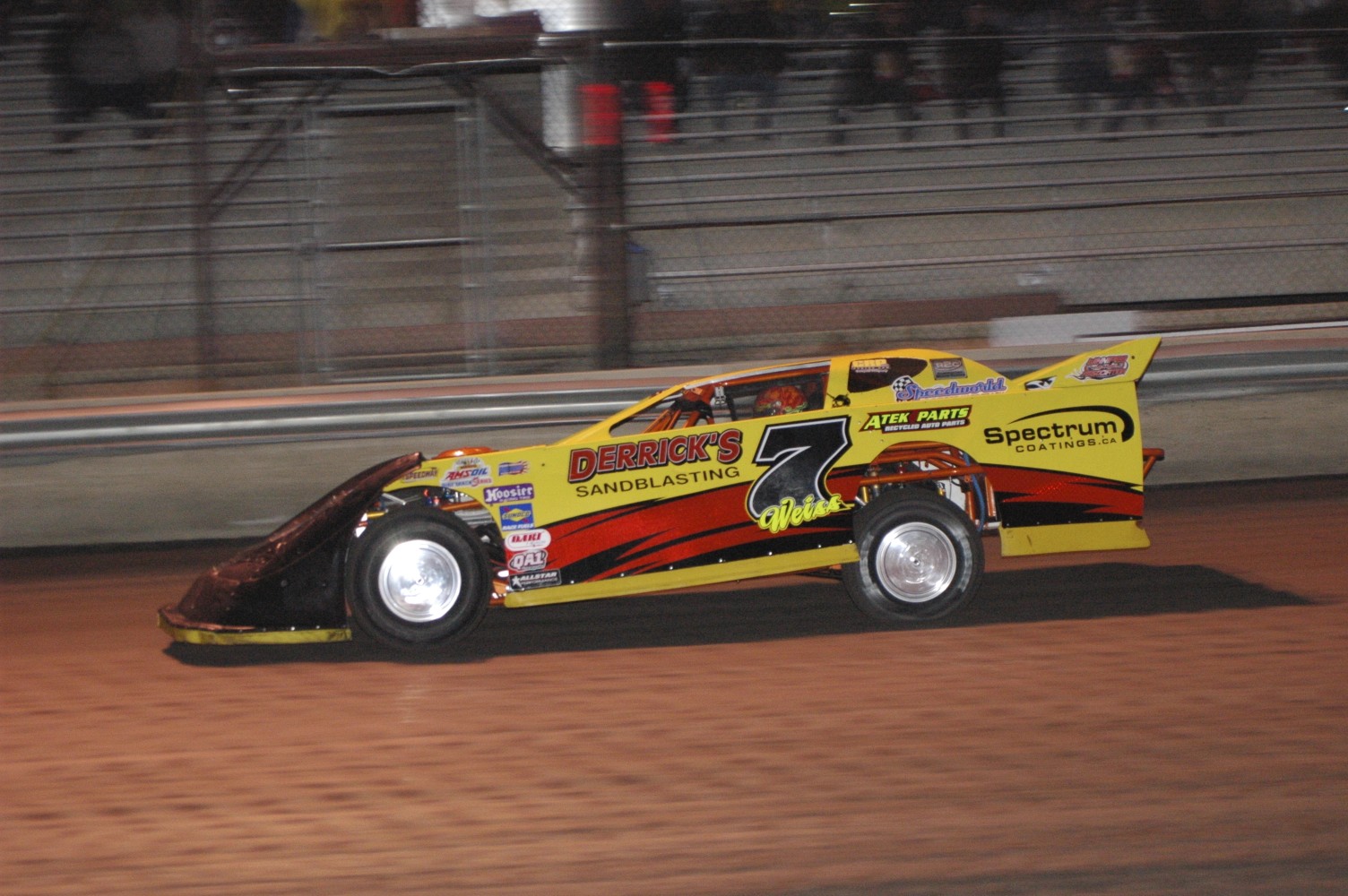 a yellow and red vehicle driving around a track