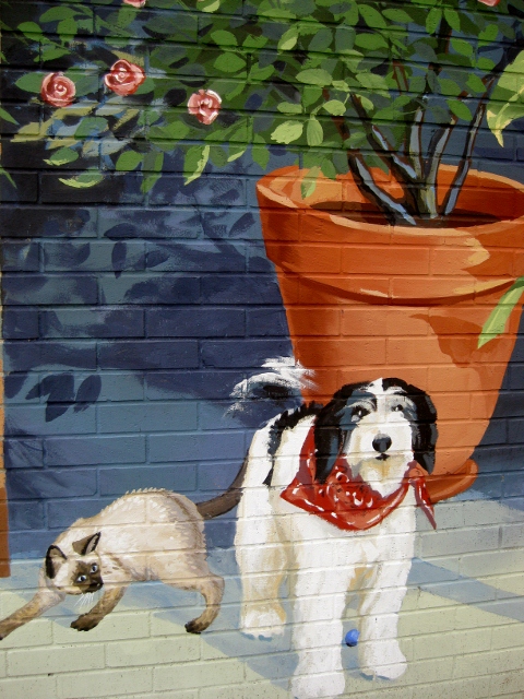 a dog, cat and ra are depicted in this colorful painted mural
