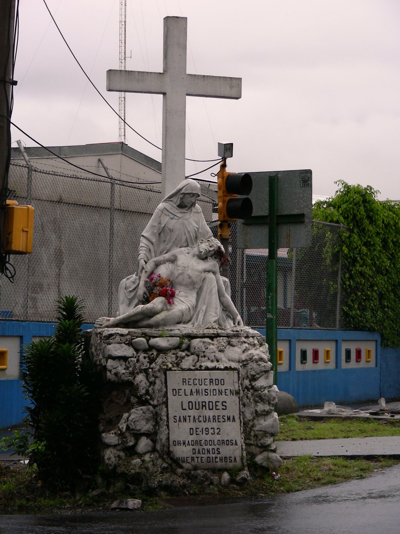 a statue with flowers next to a traffic light