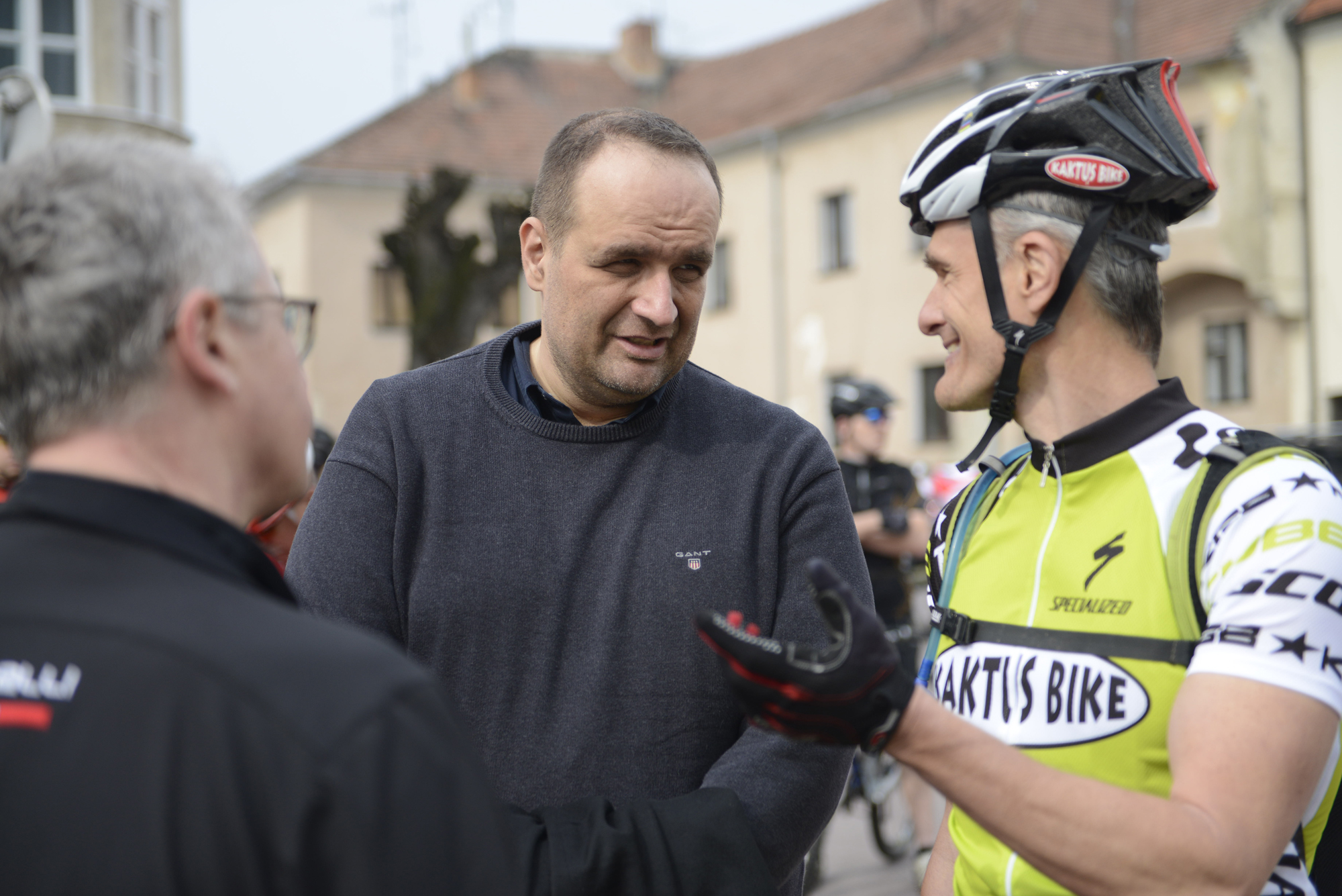 two men talking to a cyclist in the street