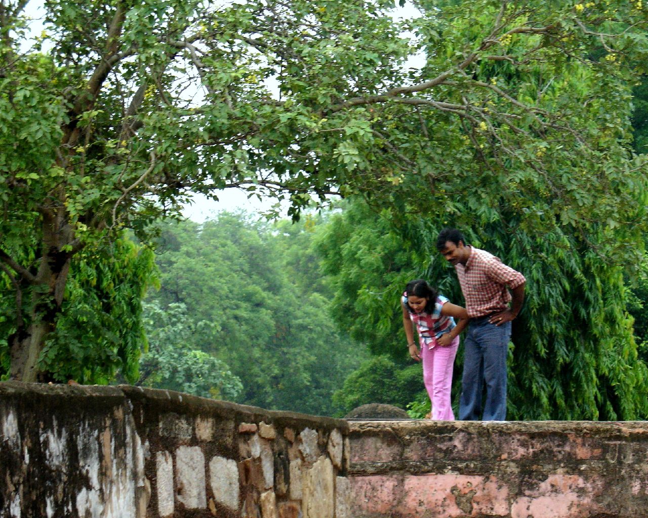 two people are standing by an empty wall