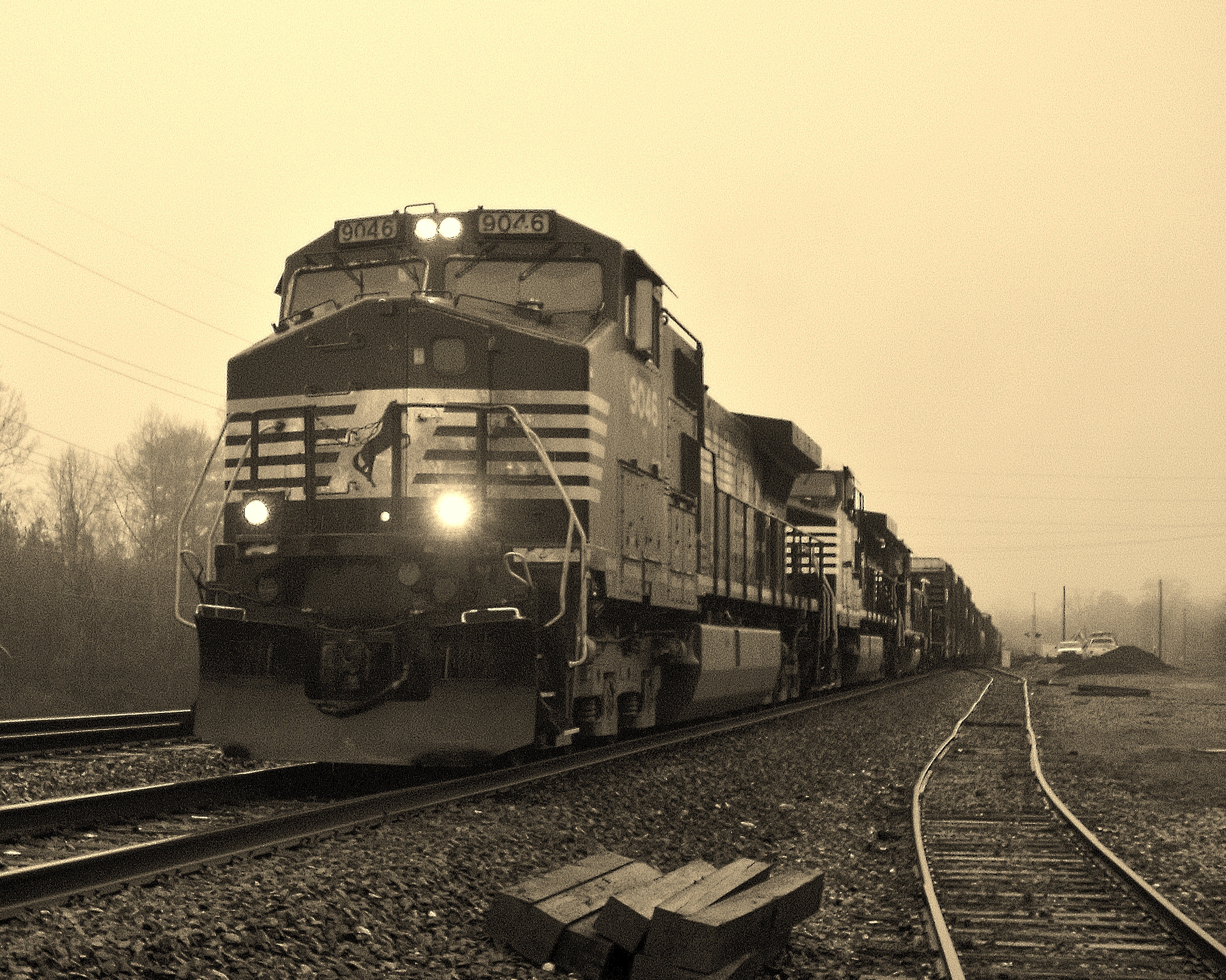 a train traveling down tracks through a foggy forest