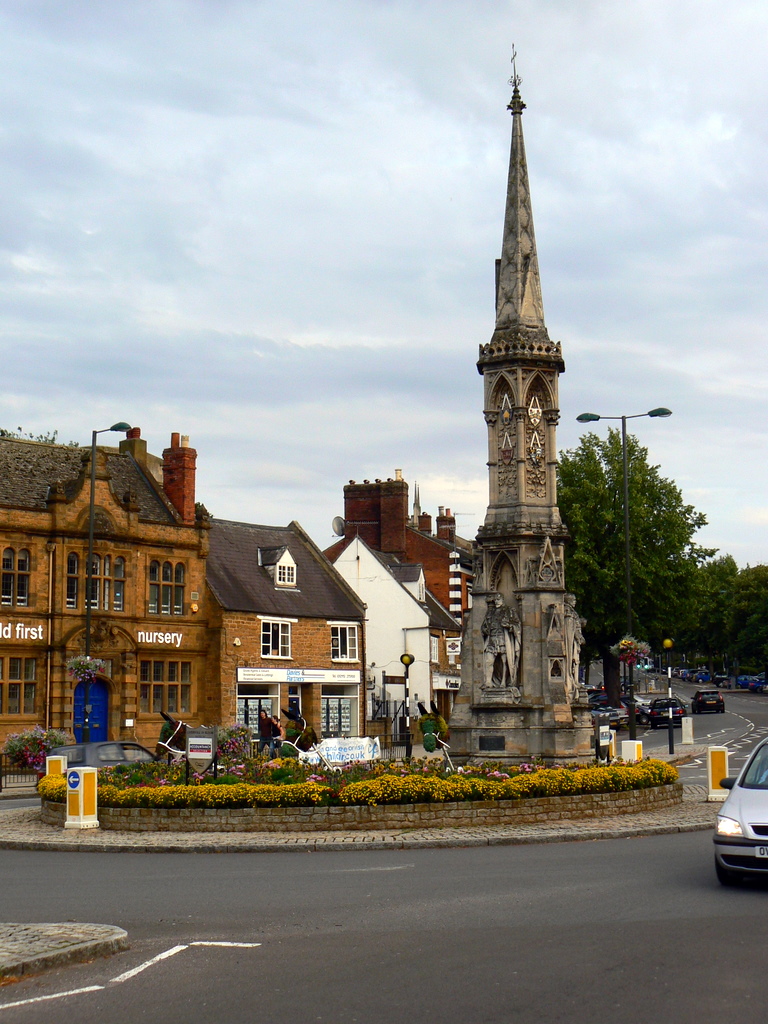 a church tower and surrounding buildings stands on the corner