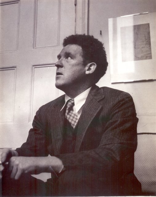 a man wearing a suit sitting down in front of a door