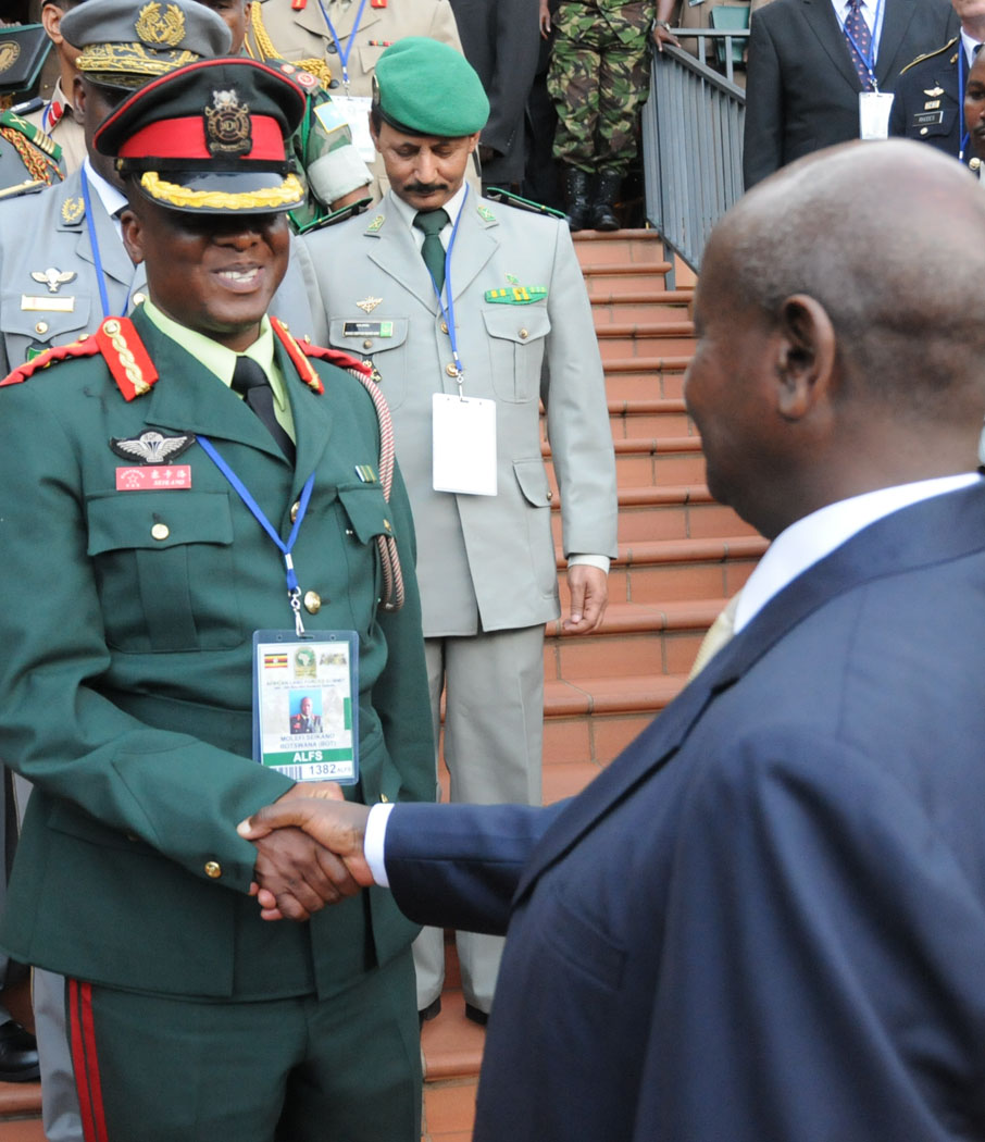 an army officer shakes hands with other uniformed men in uniform