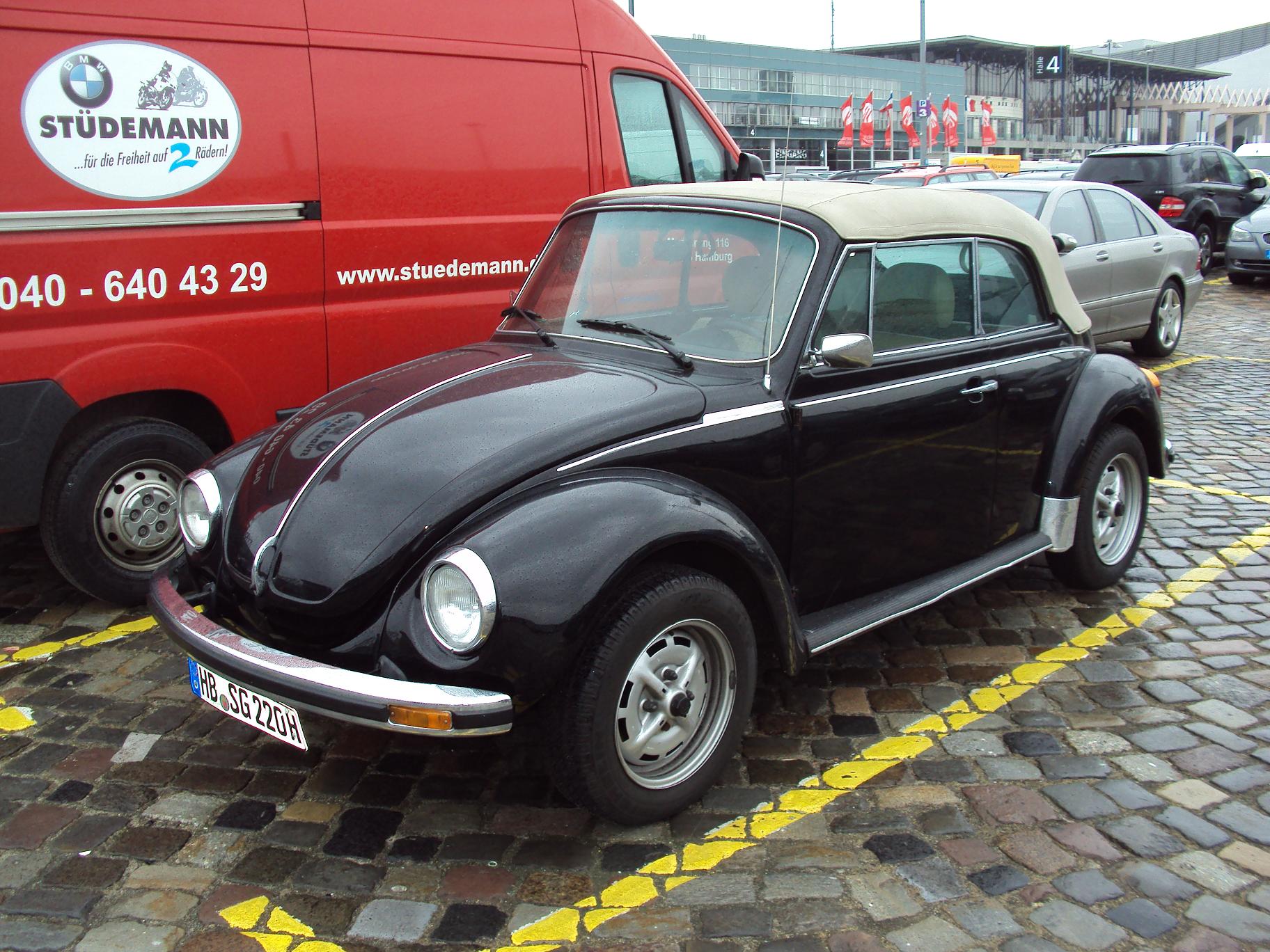 a close up of an old beetle parked on brick ground