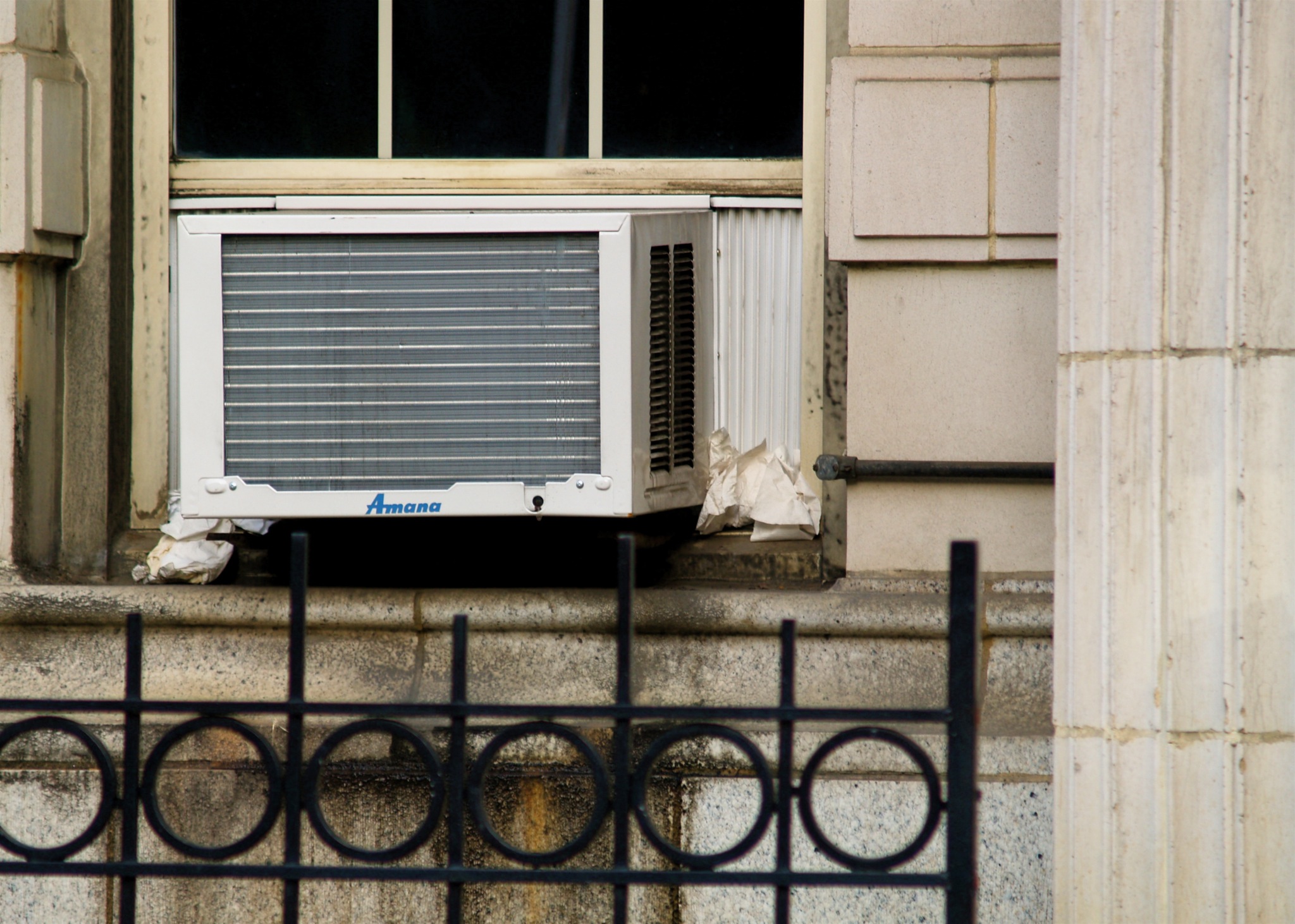 a window with a large air conditioning unit in the corner