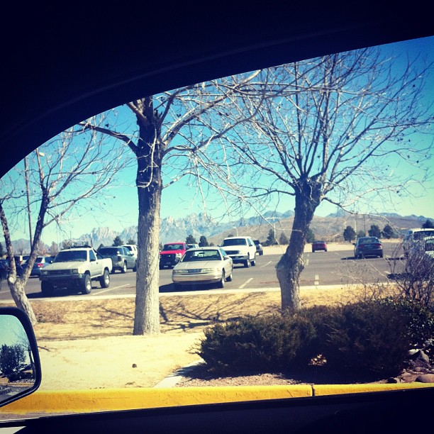 the view of a parking lot from the back window of a car