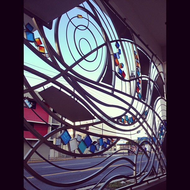 an artistic and modern stained glass window in the middle of a street