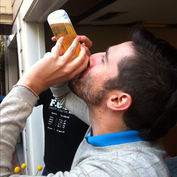 the man is drinking some beer from a cup