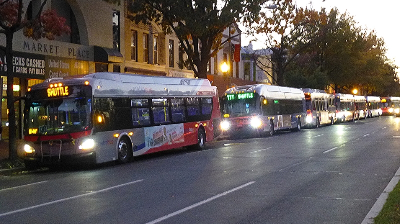 a line of buses parked on the side of the street