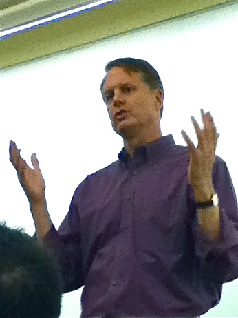 a man is standing up at an event, with his hands in the air