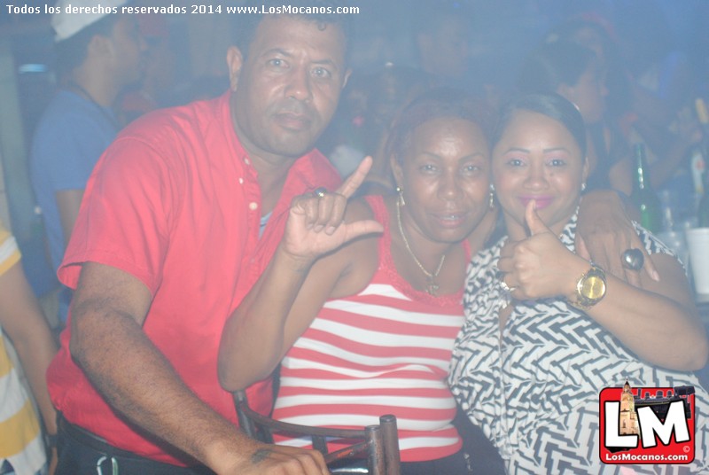 three people posing for the camera in a nightclub