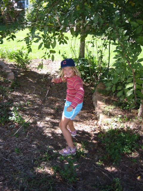 a child is standing in the woods playing with a frisbee