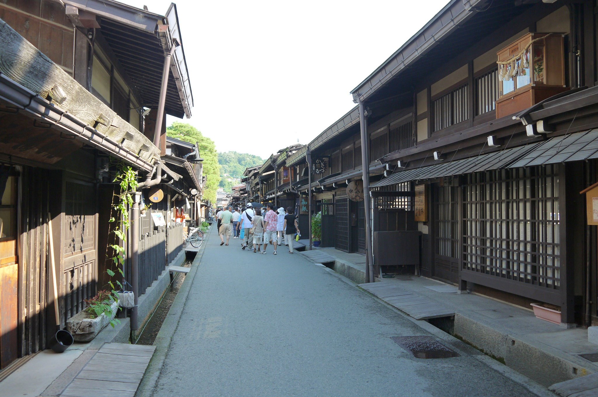 people walk down a street in an old city