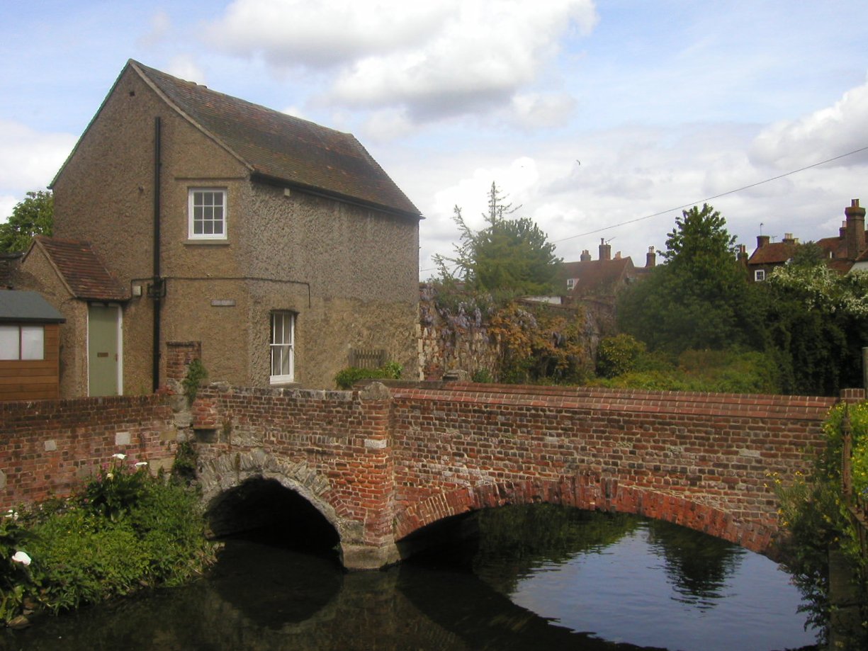 the brick bridge crosses over a small pond near the village