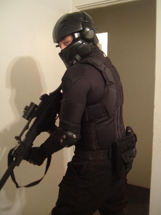 a person in a dark uniform holding a rifle