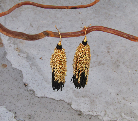 pair of earrings hanging on nch on cement surface