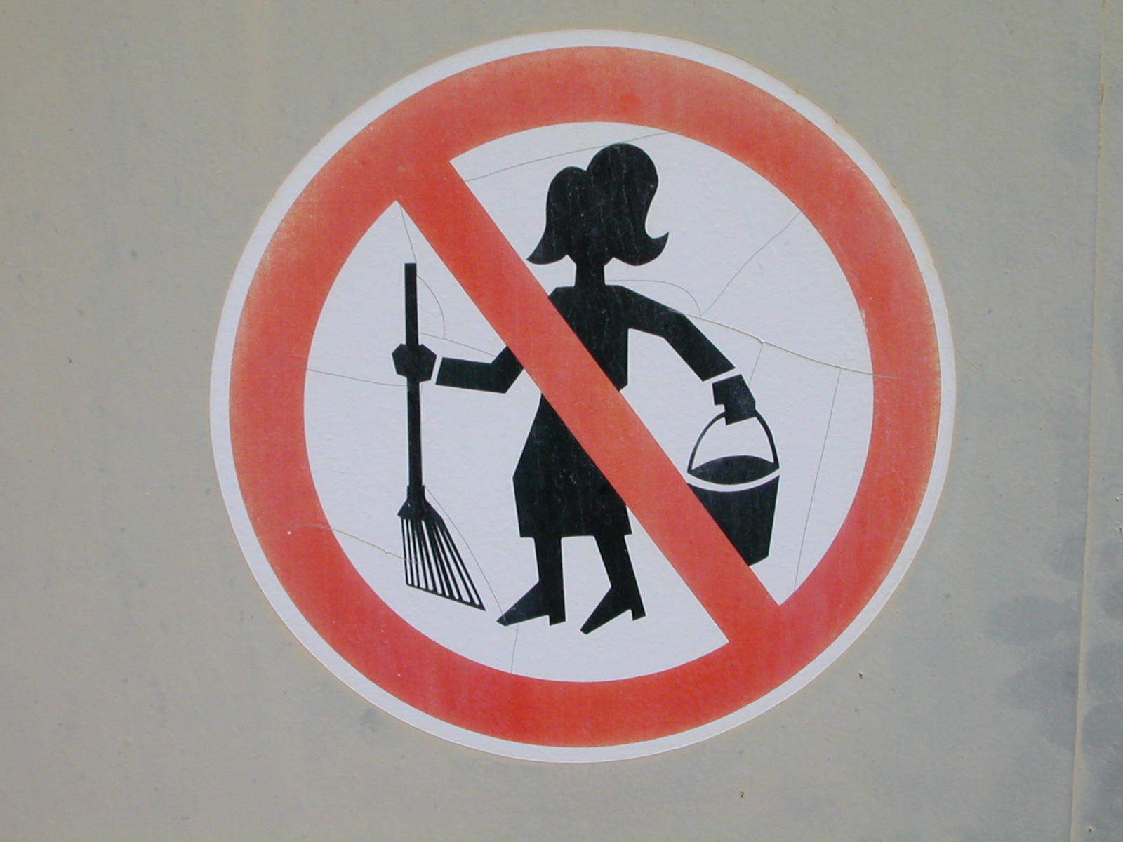 a sign depicting a woman cleaning the ground