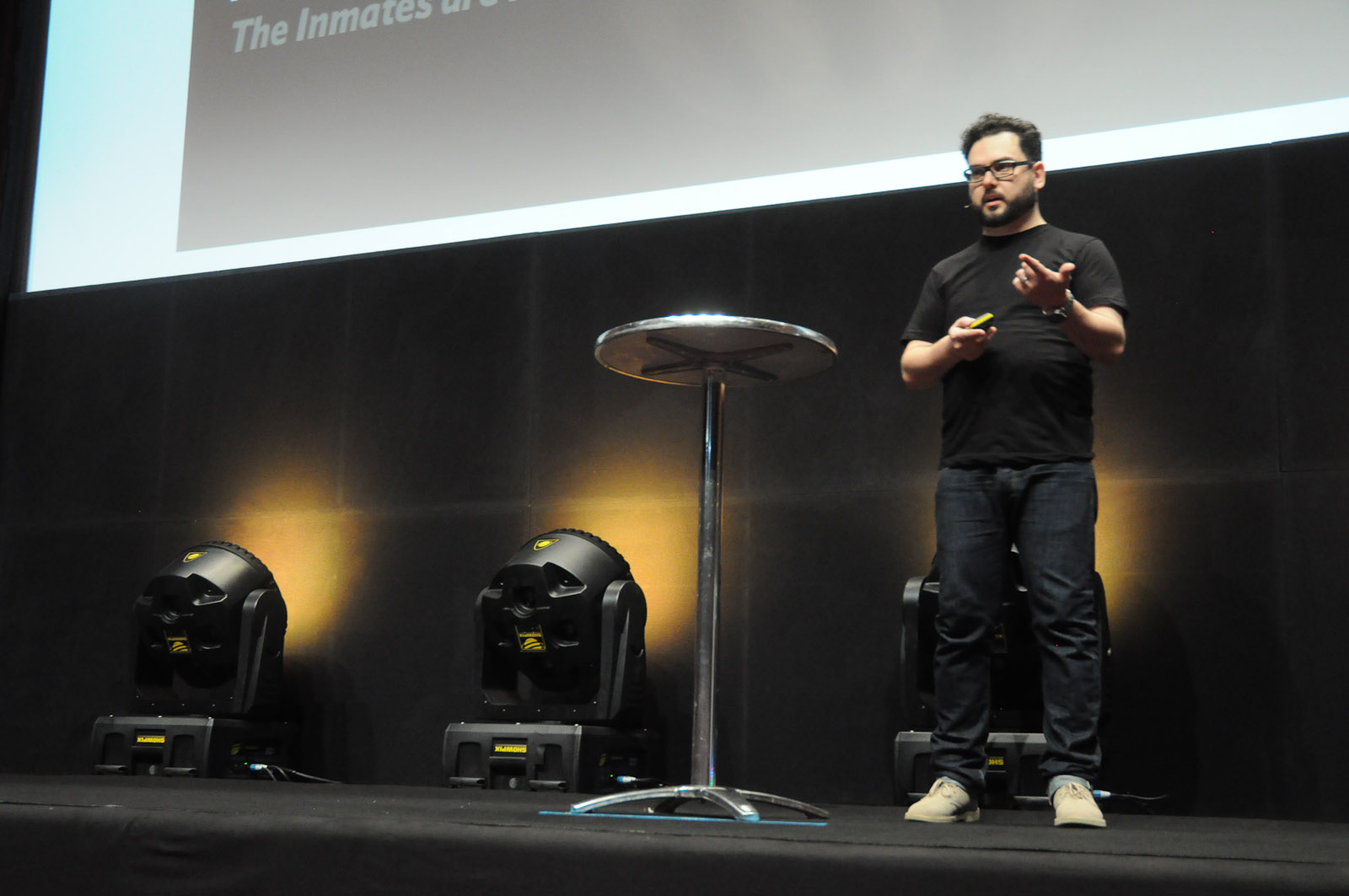 a man standing next to a microphone and table