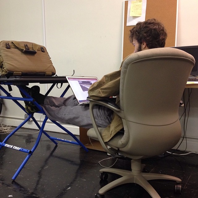 a person sitting in an office chair at a desk with papers on it