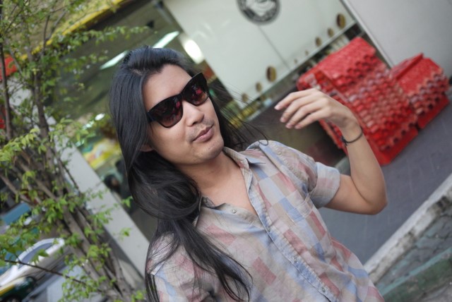 a lady wearing a shirt holding a red purse on the street