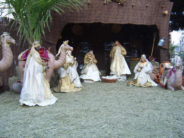 a group of nativity figurines is posed in a desert setting