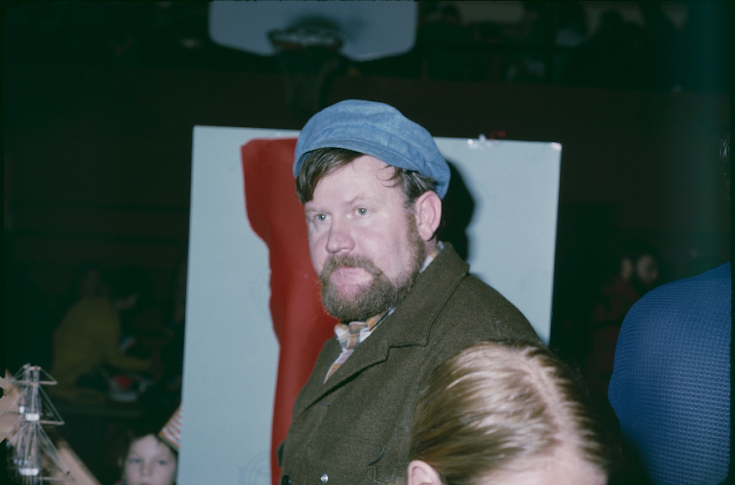 a man sitting in a chair wearing a blue hat