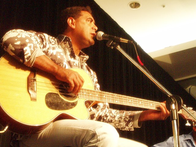 the man is playing a guitar while singing into the microphone