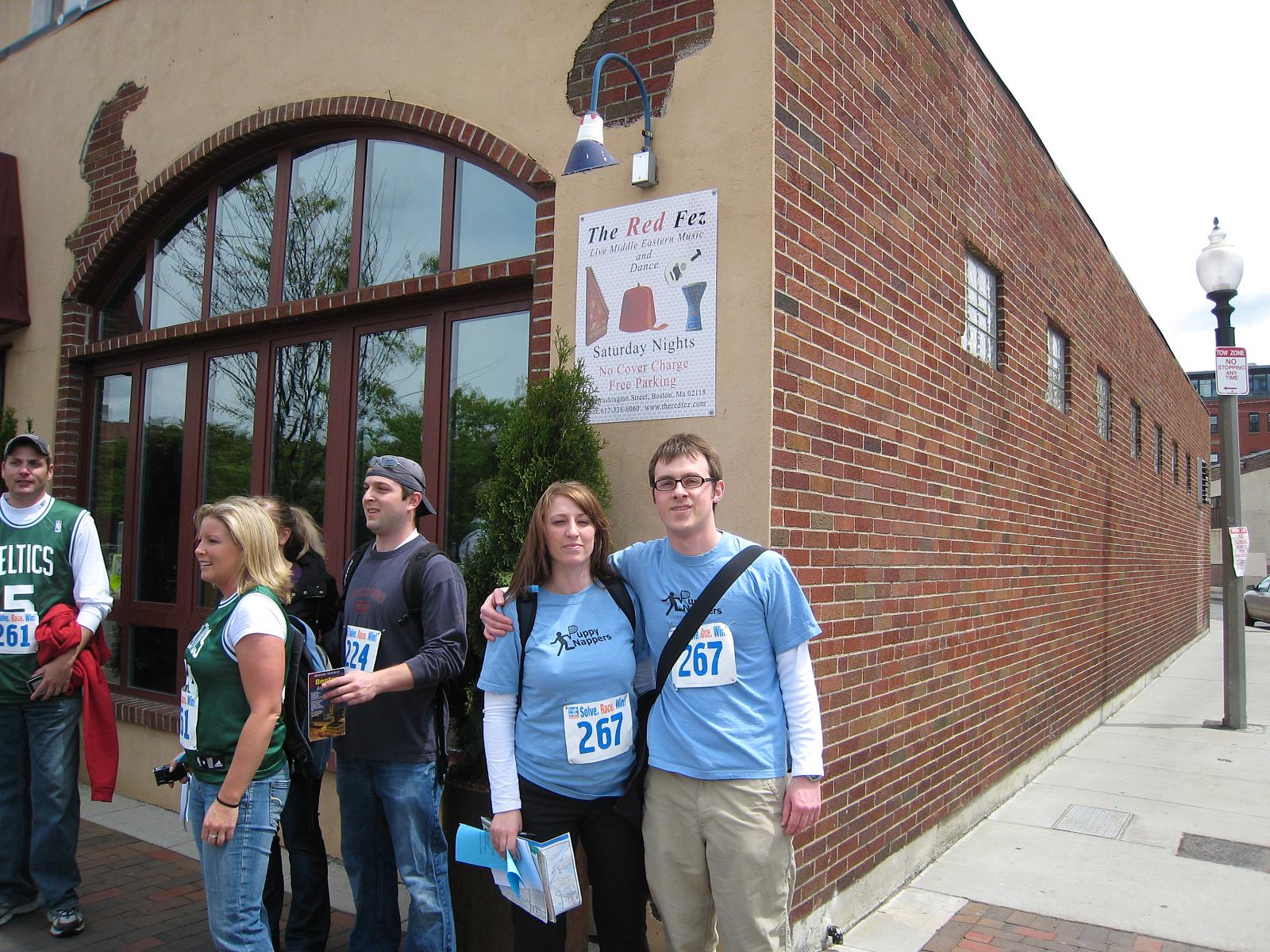 several people standing outside of a brick building