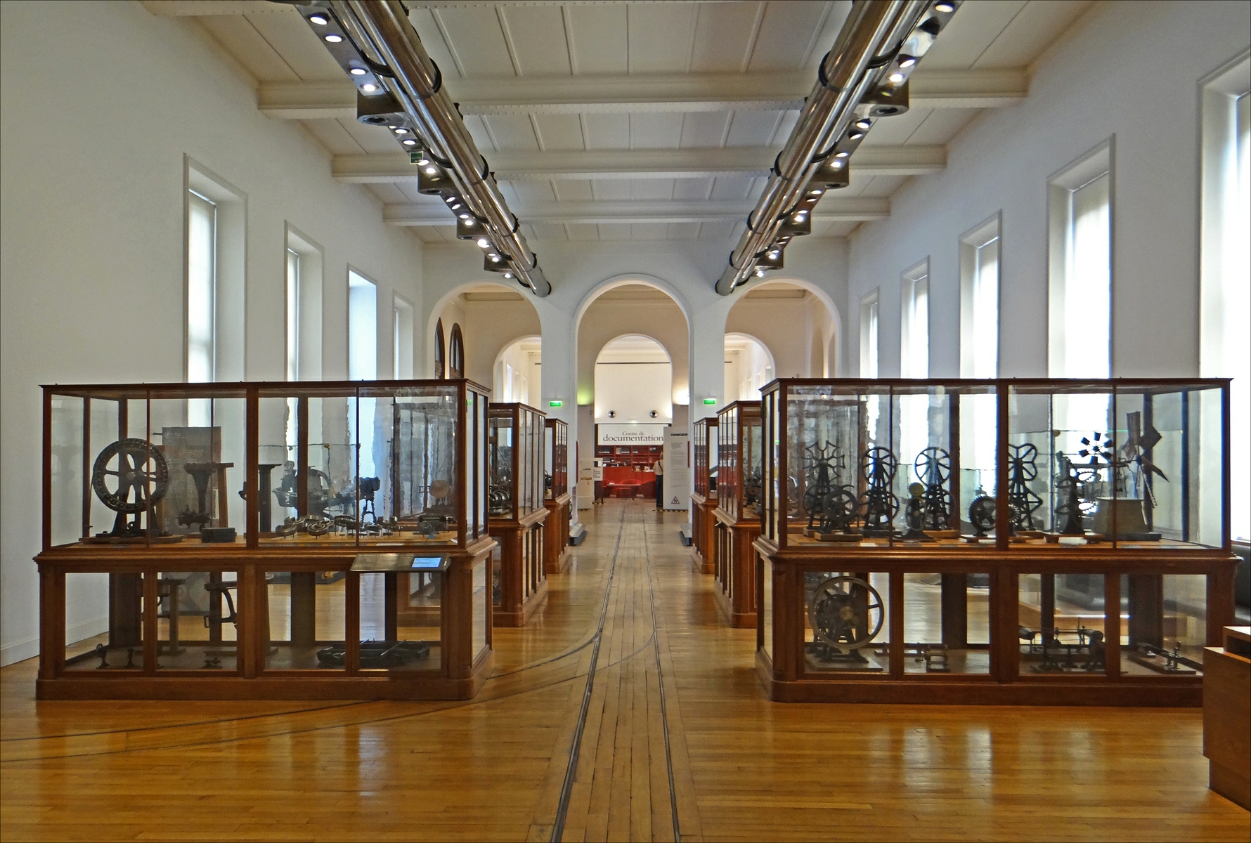 an empty museum with many cases and clocks