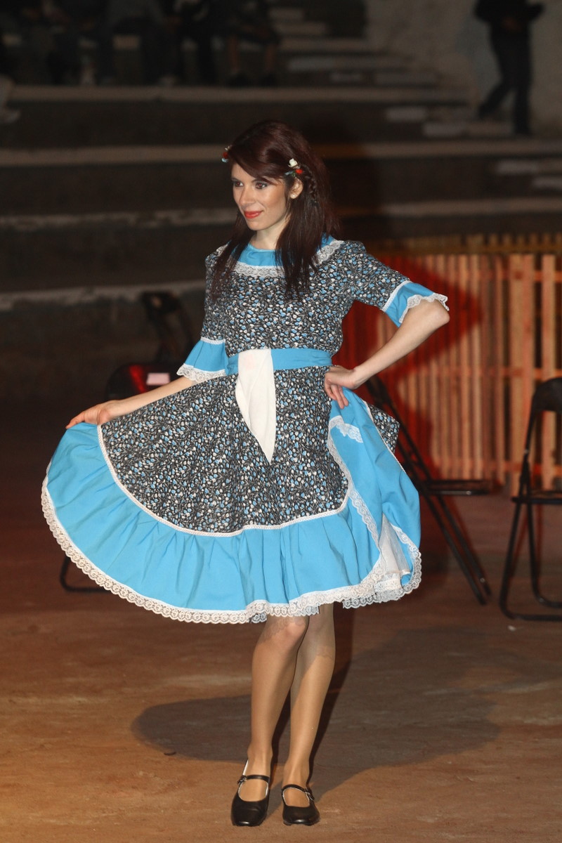 a woman is posing in a dress with laces and a bow