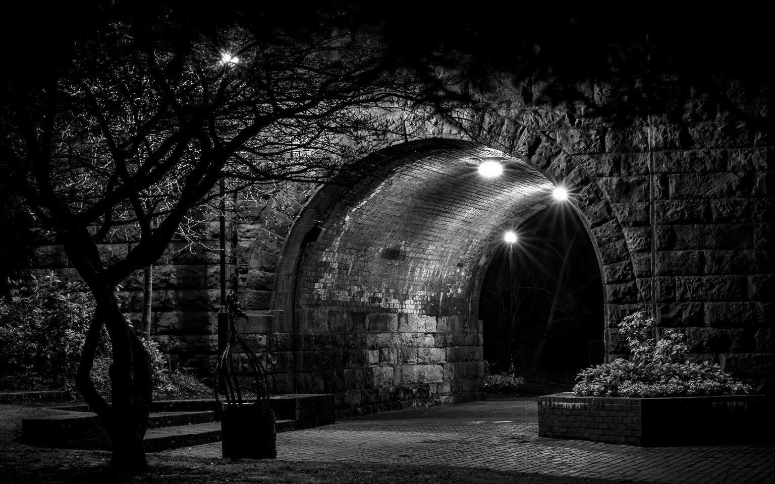 a black and white po of an arch in an old brick building