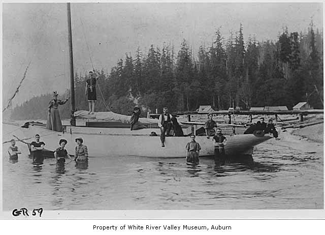 a group of men standing on top of a white boat in a lake