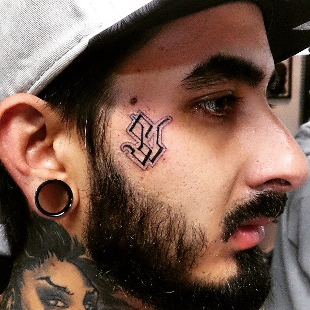 a close up of a man with a tatoo on his forehead
