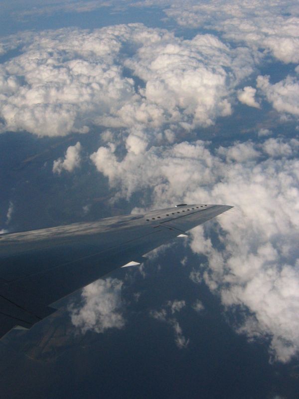 the wing of an airplane flying through the sky