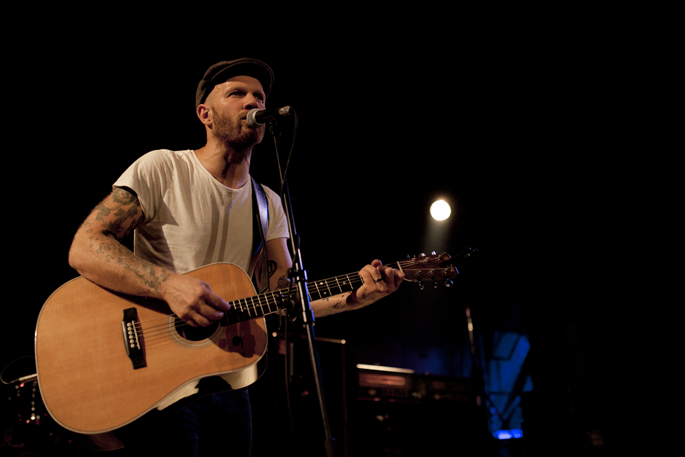 the guitar player is singing into a microphone