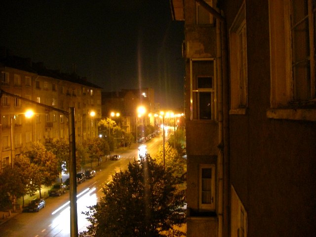 street view of street at night with lit buildings