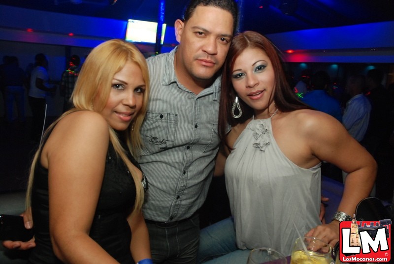 three beautiful women posing with a man in a gray shirt