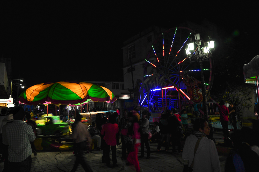 a carnival at night with people walking around